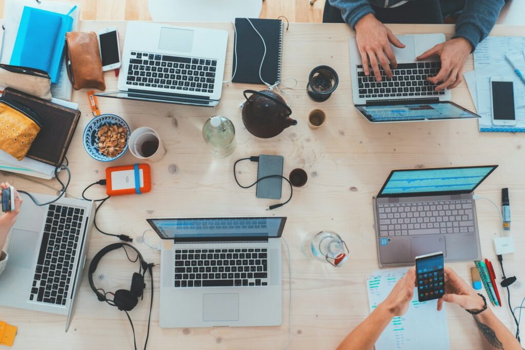 People collaborating with laptops at a table